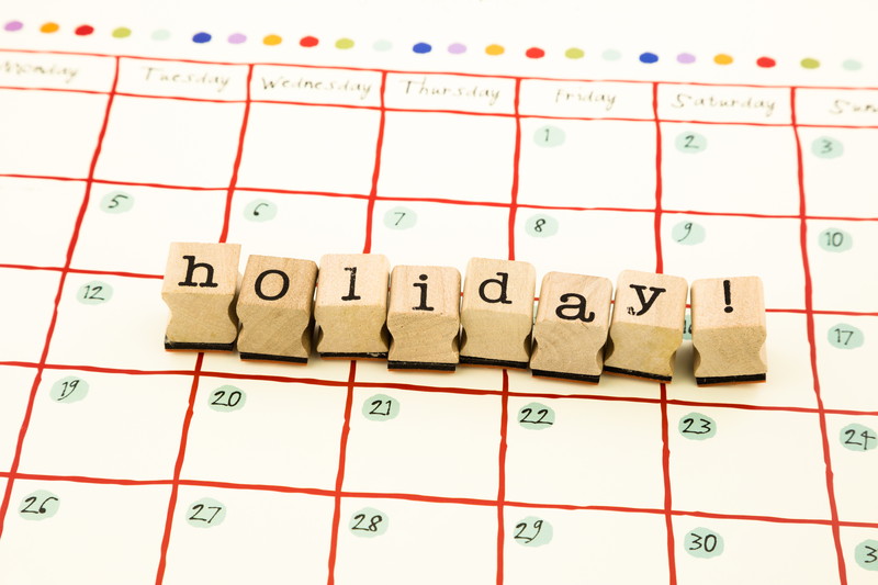 closeup holiday wording stack on calendar, reminder vacation concept and idea