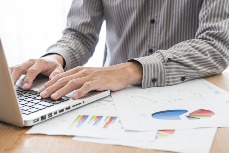 Businessman analyzing investment charts with laptop. Accounting